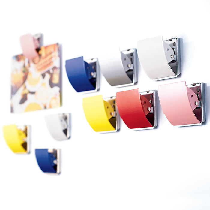 Rubber-coated magnet clips holding papers on a metal surface
